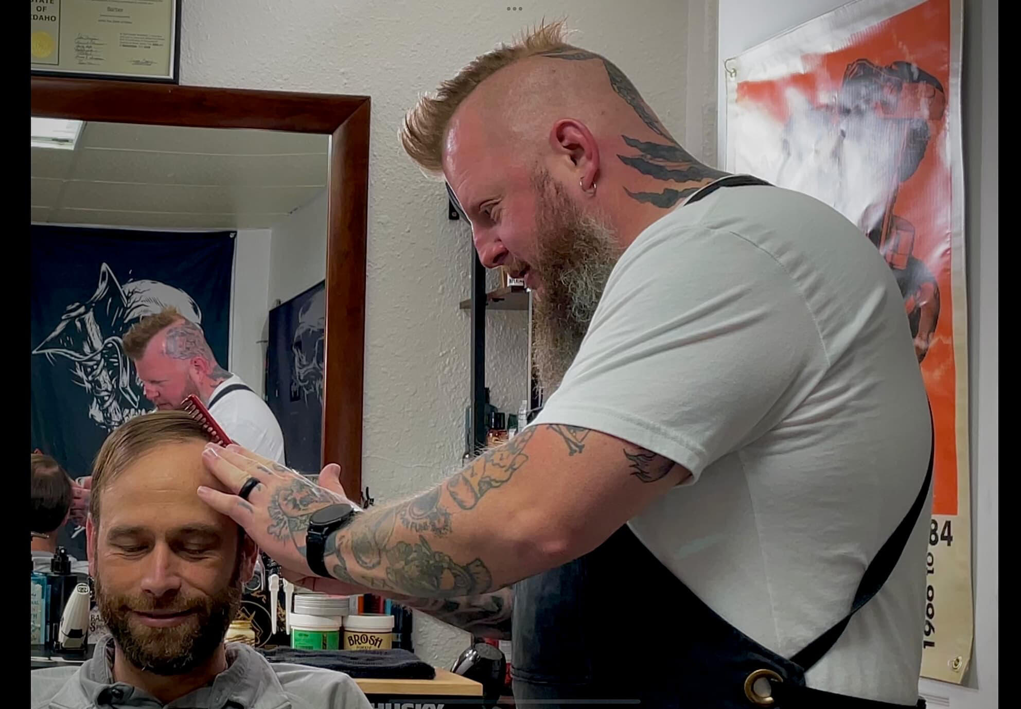Blair Whiting, master barber and owner of Knucklehead Barbershop, sculpting a client’s beard in a professional studio setting in Idaho