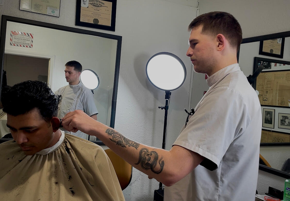 Barber Ross Wallis giving a modern fade haircut to a client at Knucklehead Barbershop in Idaho